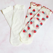 pair of socks. one strawberry pattern. one white with dots. soft, stretchy material. sheer pattern.