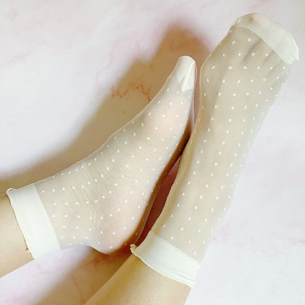 pair of socks. one strawberry pattern. one white with dots. soft, stretchy material. sheer pattern.