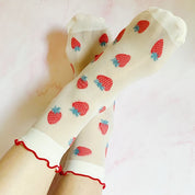 pair of socks. one strawberry pattern. one white with dots. soft, stretchy material. sheer pattern.