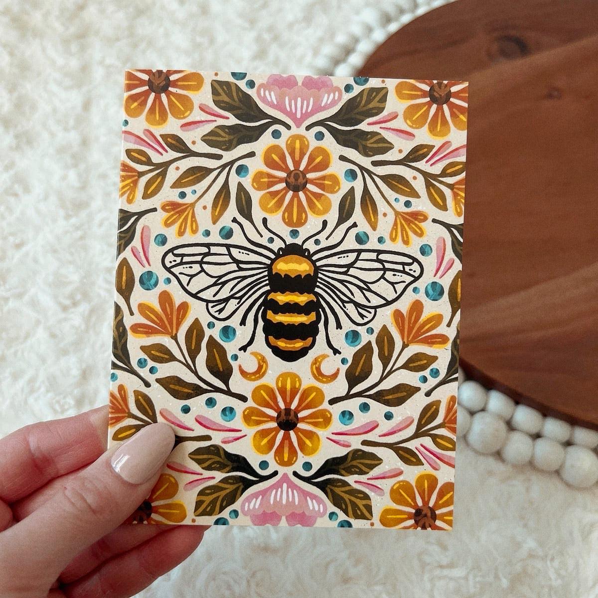 Bee & Floral design. Hand drawn Greeting Card. Hand holding card. 