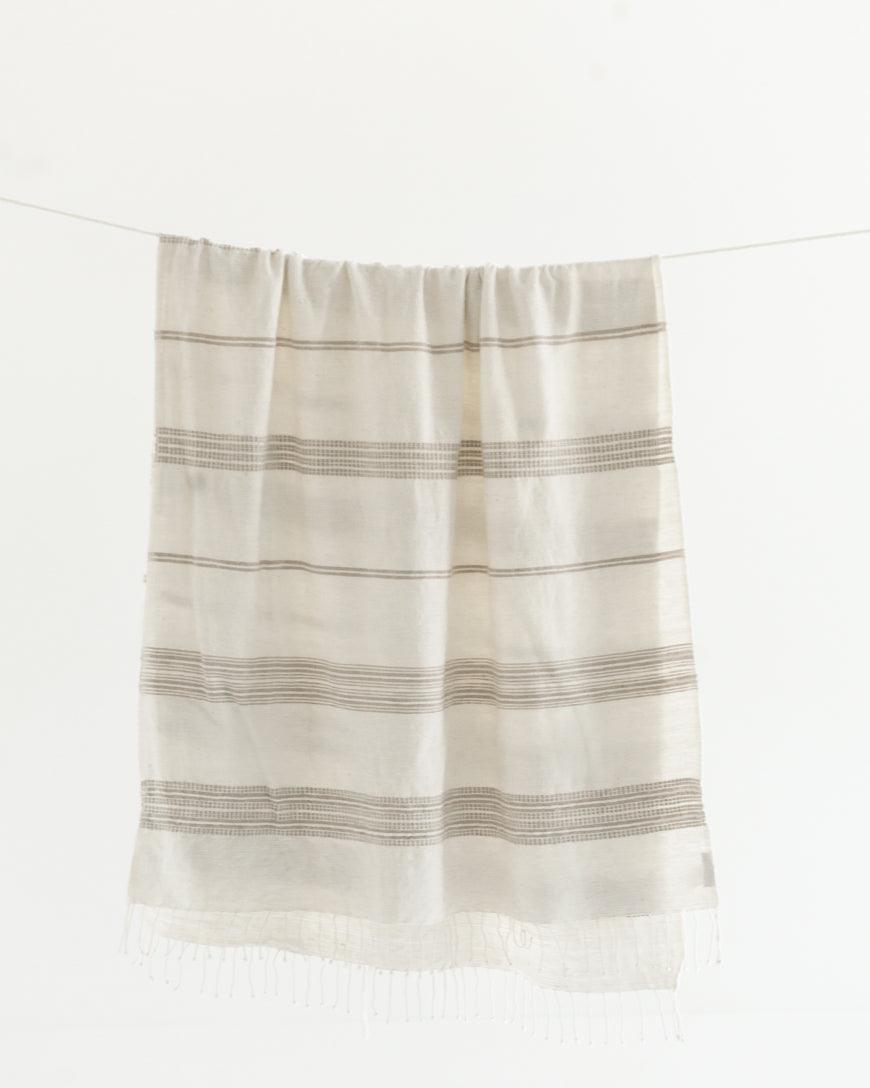 Ethically crafted in Ethiopia. Cotton throw blanket. Measures 38 x 72 inches. natural with stone. 